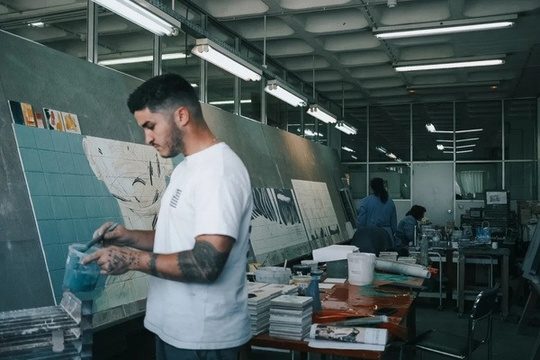 Hopare dans l'atelier de la manufacture, devant les panneaux de carreaux